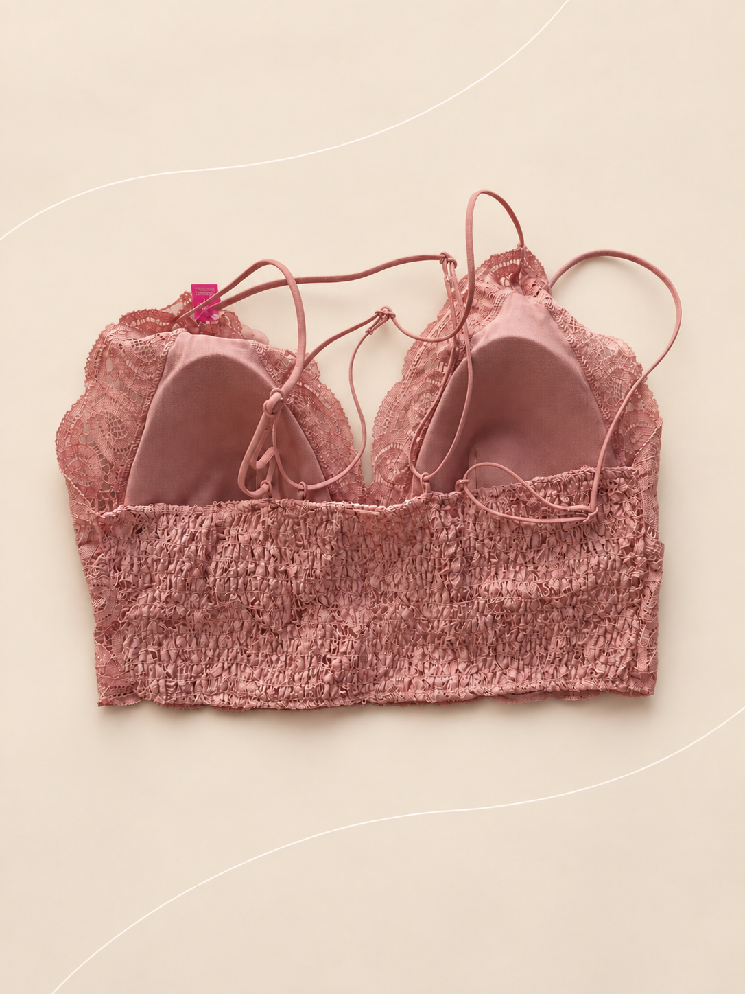 Bralette V'S de Encaje Rosa Malva, vista dorsal sobre fondo crema de líneas suaves