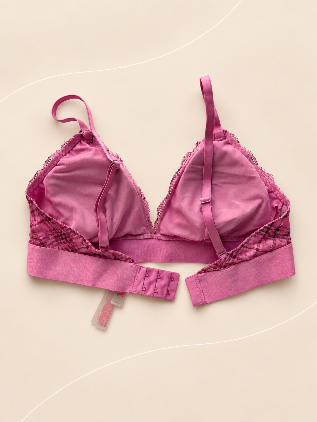 Bralette V'S de Encaje Rosa con Estampado Floral, vista dorsal sobre fondo crema de líneas suaves