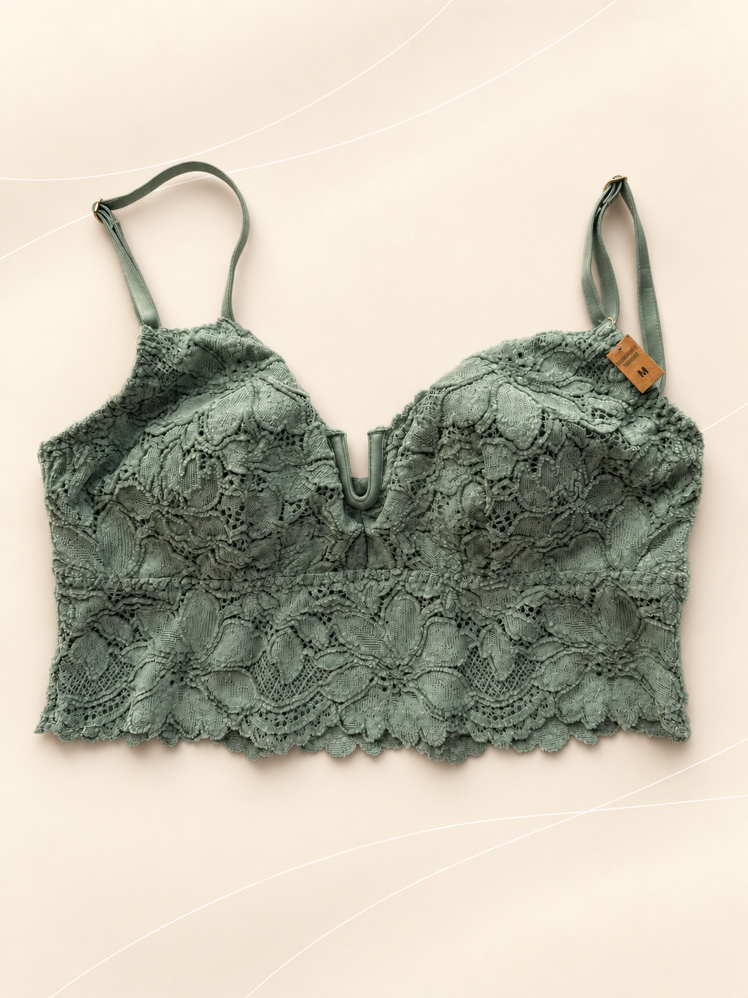 Bralette V'S Bustier de Encaje Verde Salvia, vista frontal sobre fondo crema de líneas suaves