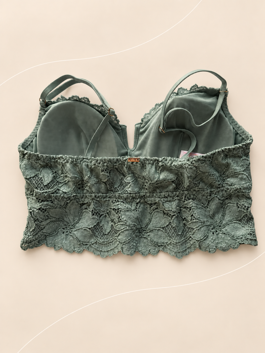 Bralette V'S Bustier de Encaje Verde Salvia, vista dorsal sobre fondo crema de líneas suaves