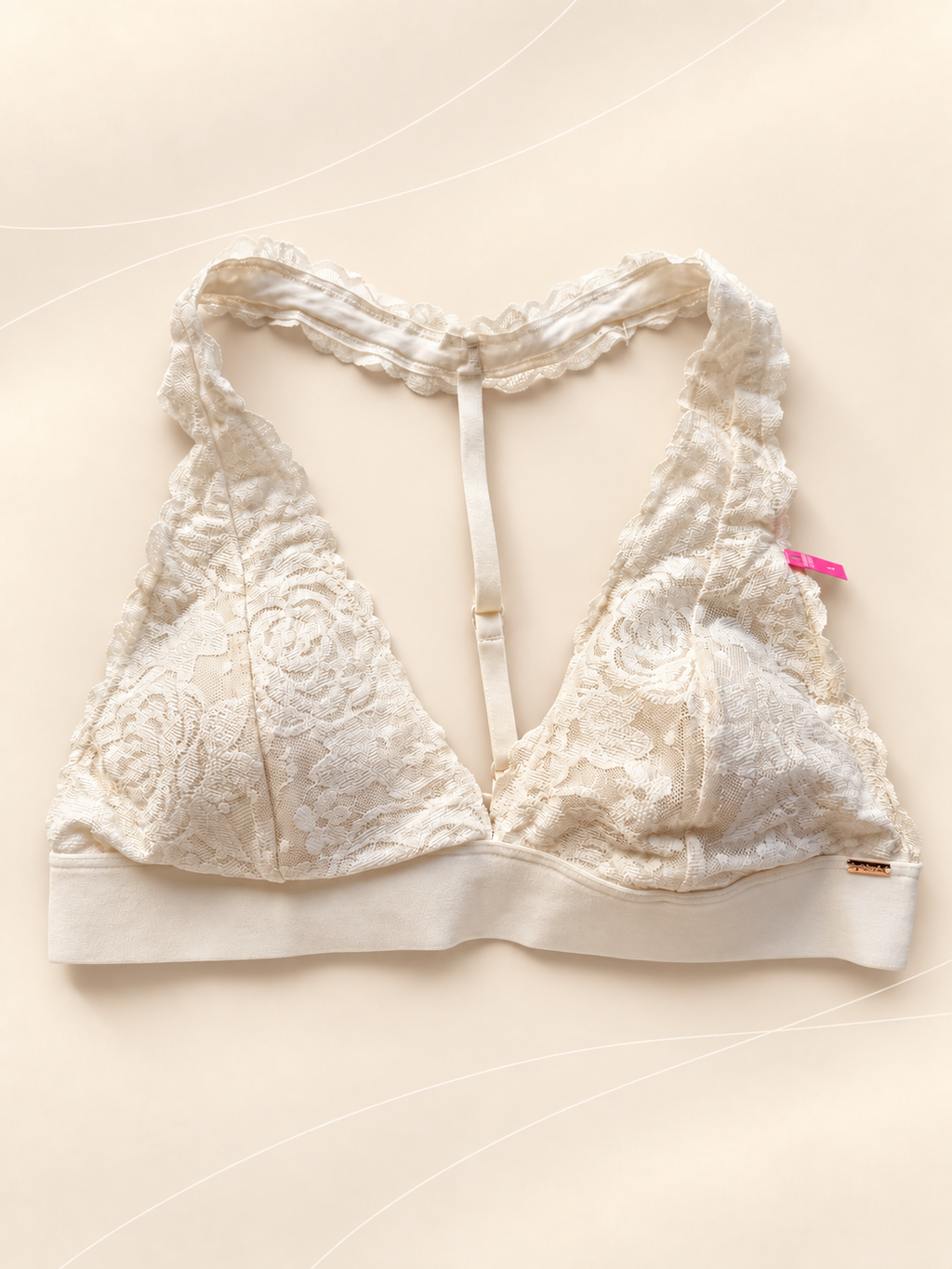 Bralette V'S de Encaje Blanco con Espalda Racerback, vista frontal sobre fondo crema de líneas suaves