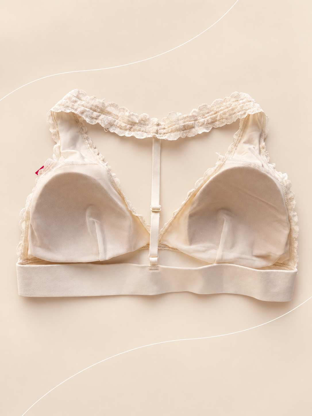 Bralette V'S de Encaje Blanco con Espalda Racerback, vista dorsal sobre fondo crema de líneas suaves
