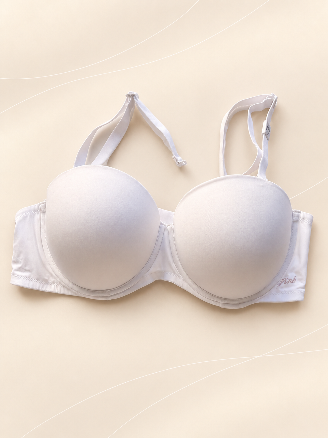 Corpiño Pink Strapless - Push Up Liso, Blanco, vista frontal sobre fondo crema de líneas suaves