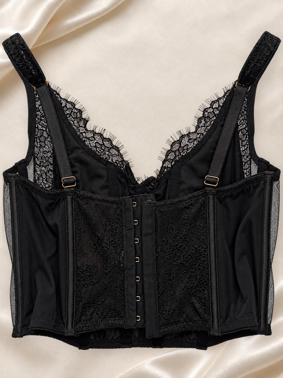 Corset Bustier Negro de Encaje con Detalles Cruzados, vista dorsal sobre fondo marfil
