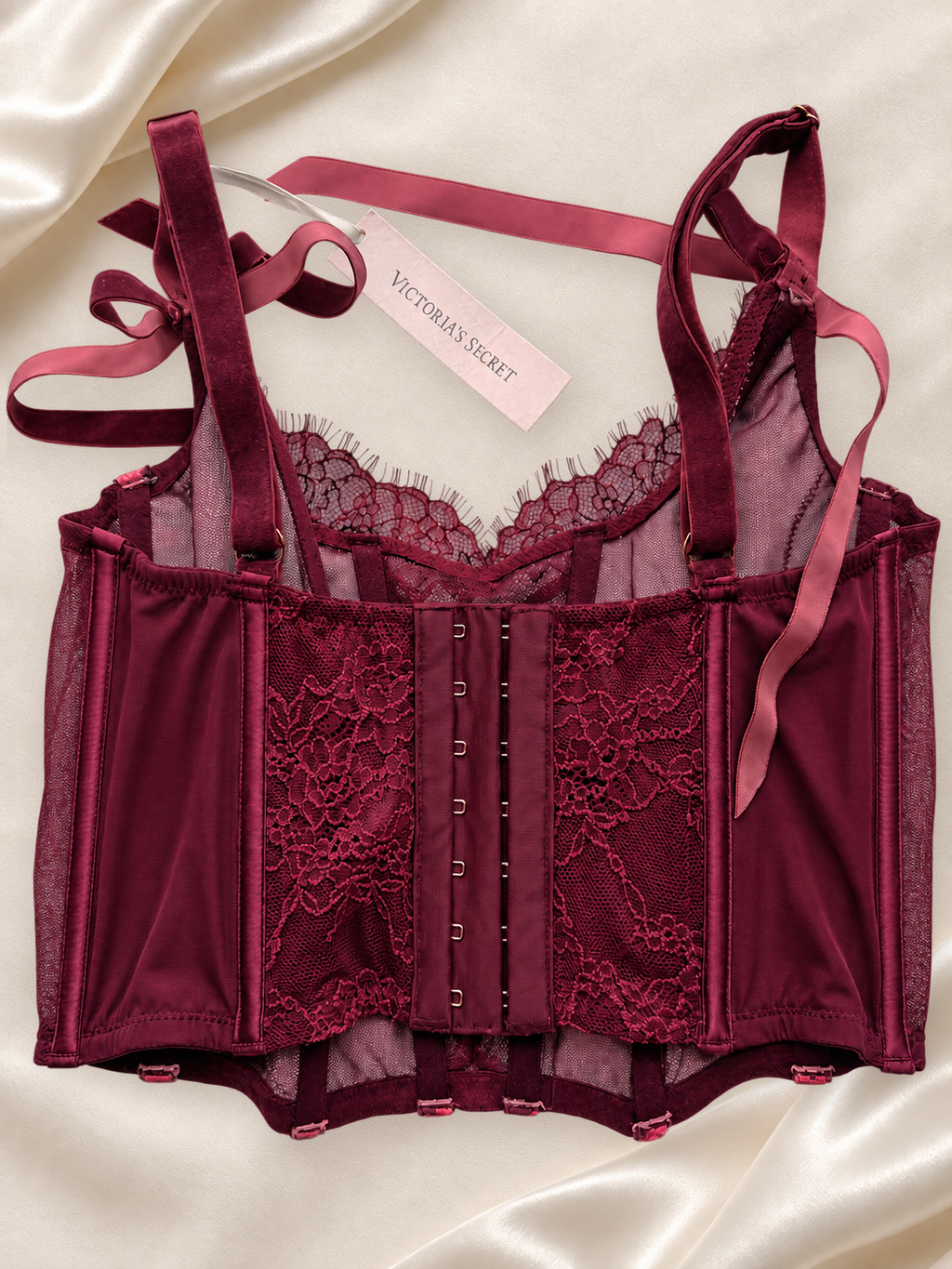 Corset V'S Floral Bordeaux con Encaje y Lazos Decorativos, vista dorsal sobre fondo marfil