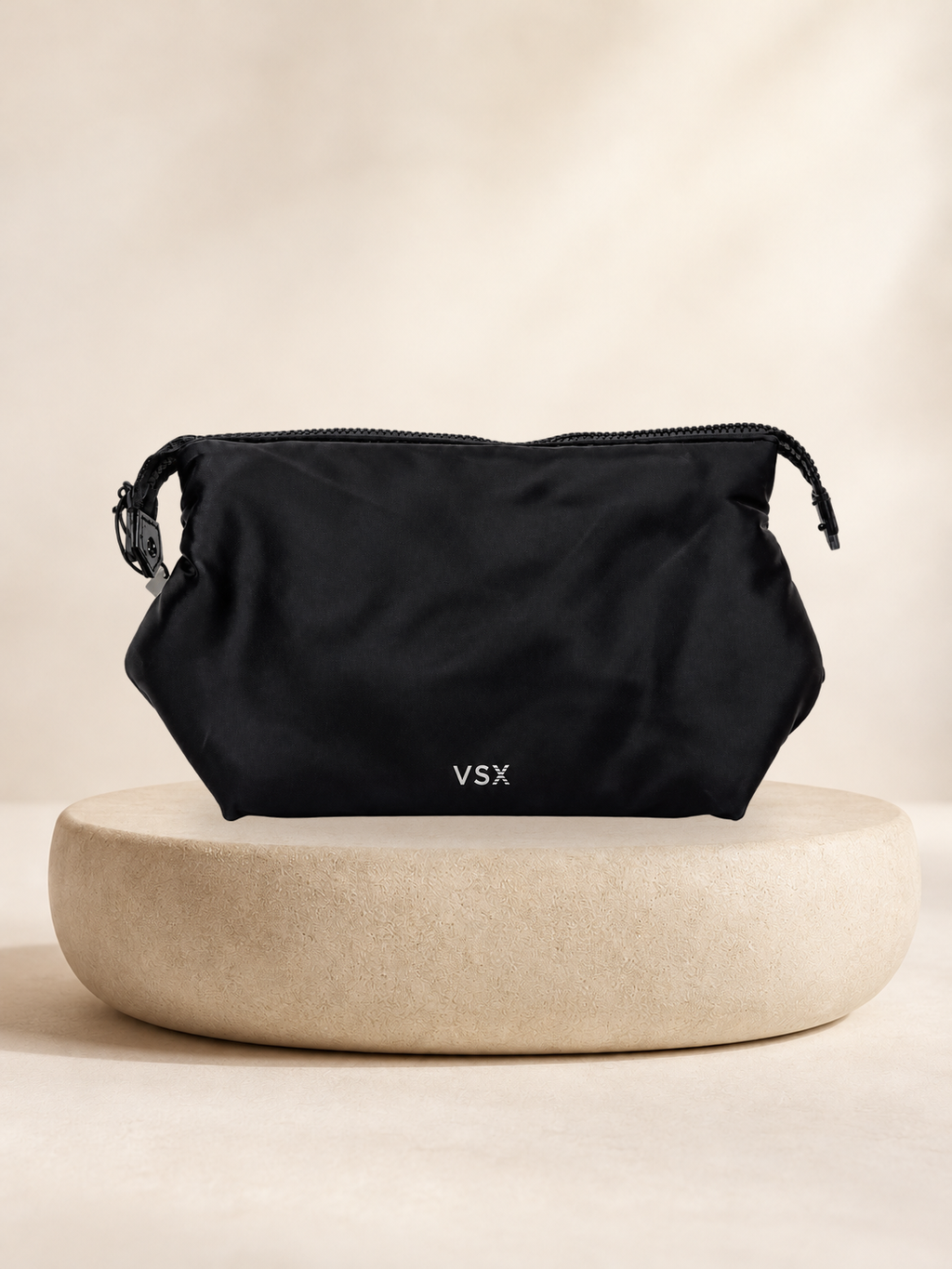Neceser VSX deportivo negro con cierre superior, vista 1 sobre pedestal claro