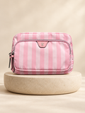 Neceser rosa rayado con bolsillo frontal y cierre sobre base circular clara