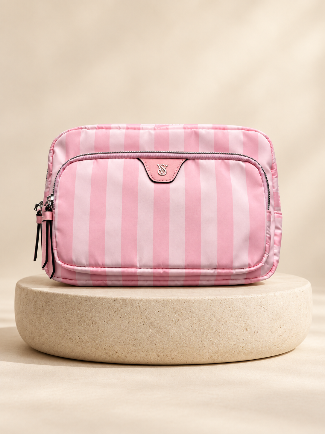 Neceser rosa rayado con bolsillo frontal y cierre sobre base circular clara