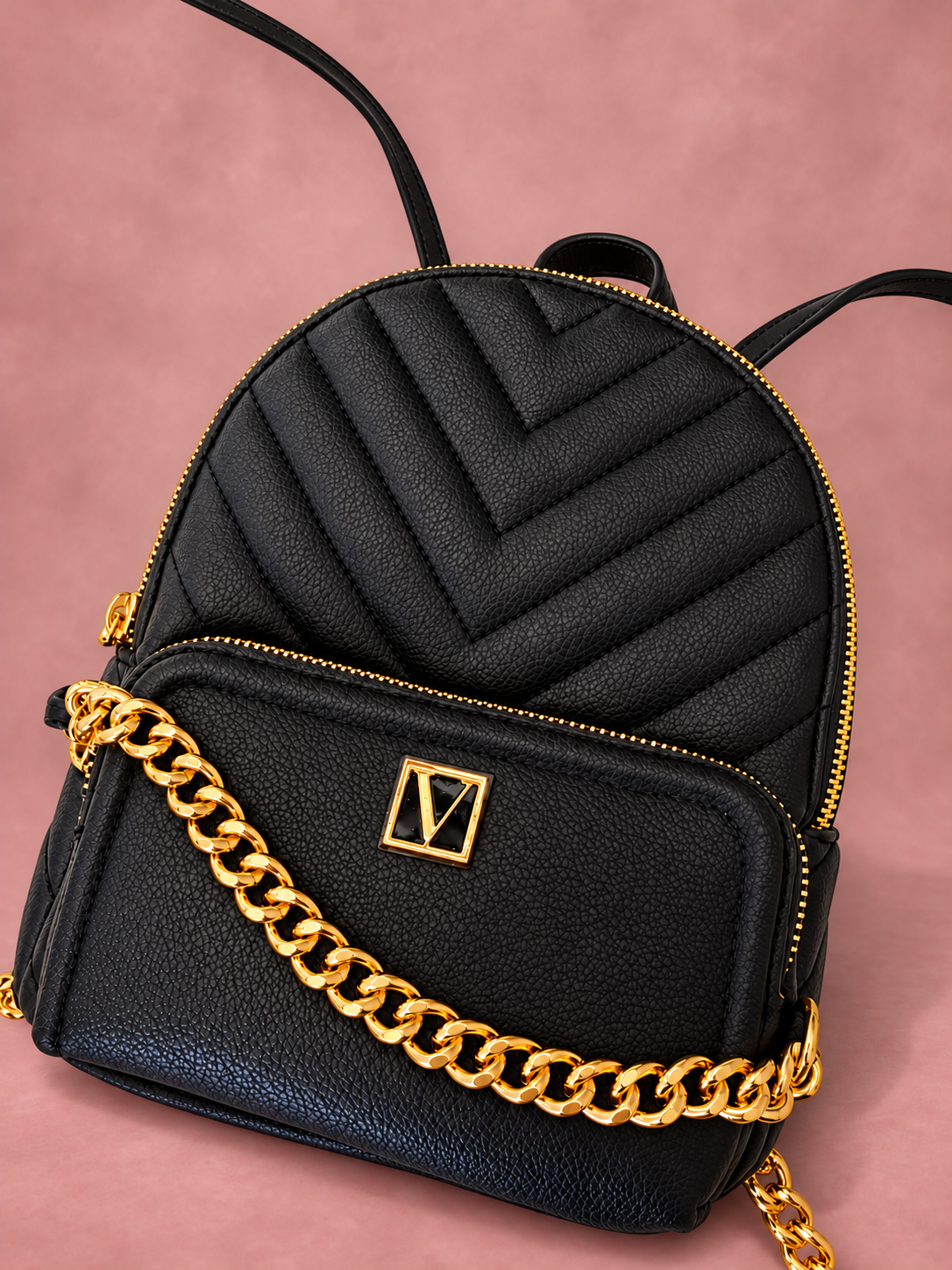 Mochila V'S negra con cadena dorada y sombra, vista 02