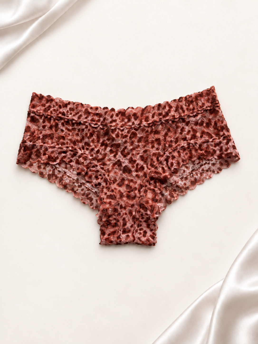 Panti de encaje con animal print en tonos salmón y marrón, vista posterior sobre fondo marfil