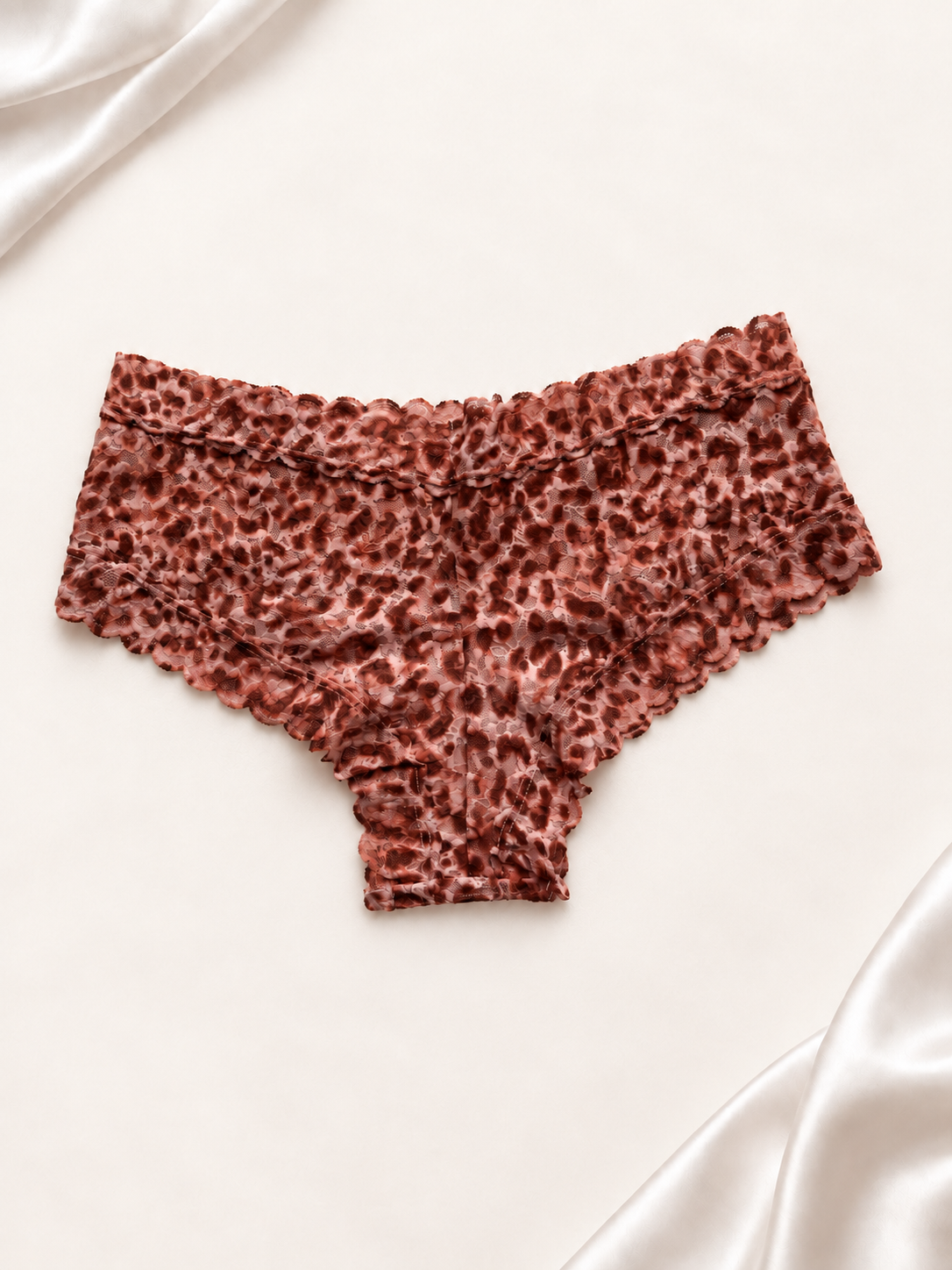 Panti de encaje con animal print en tonos salmón y marrón, vista frontal sobre fondo marfil