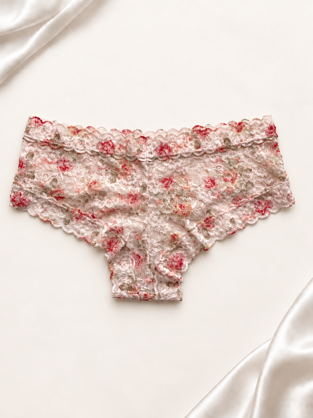 Panti de encaje blanco con estampado floral, vista trasera sobre fondo marfil