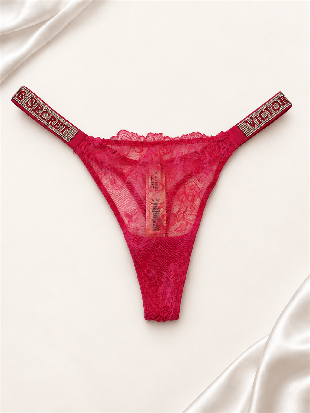 Panti V'S Rosa de Encaje con Tiras Logo Brillantes, vista frontal sobre fondo marfil