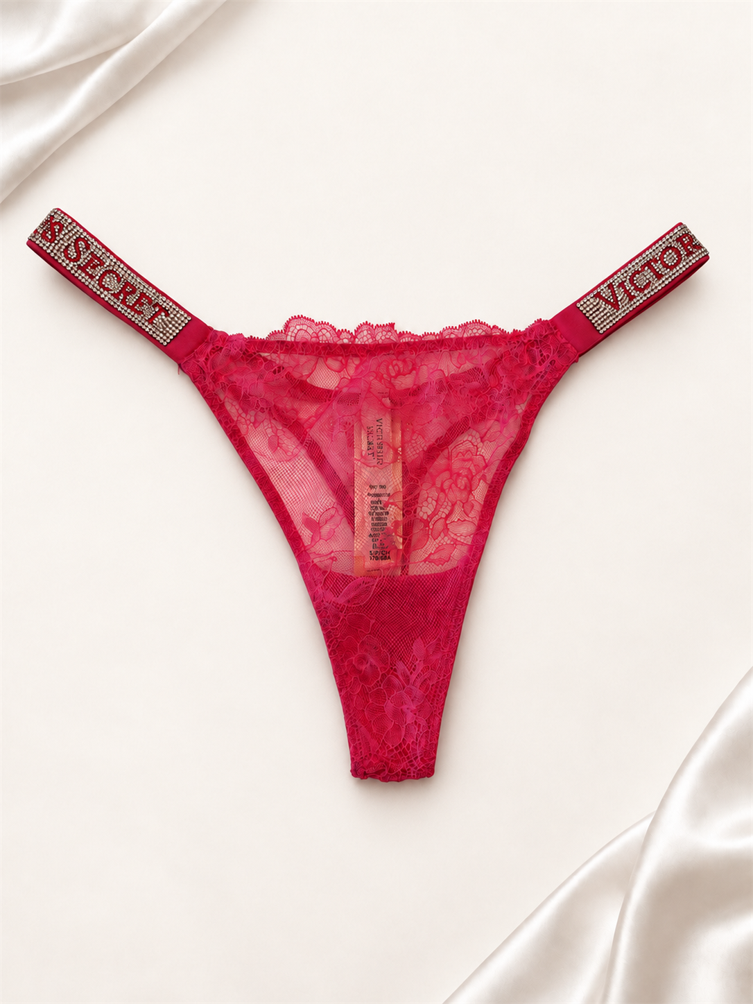 Panti V'S Rosa de Encaje con Tiras Logo Brillantes, vista frontal sobre fondo marfil
