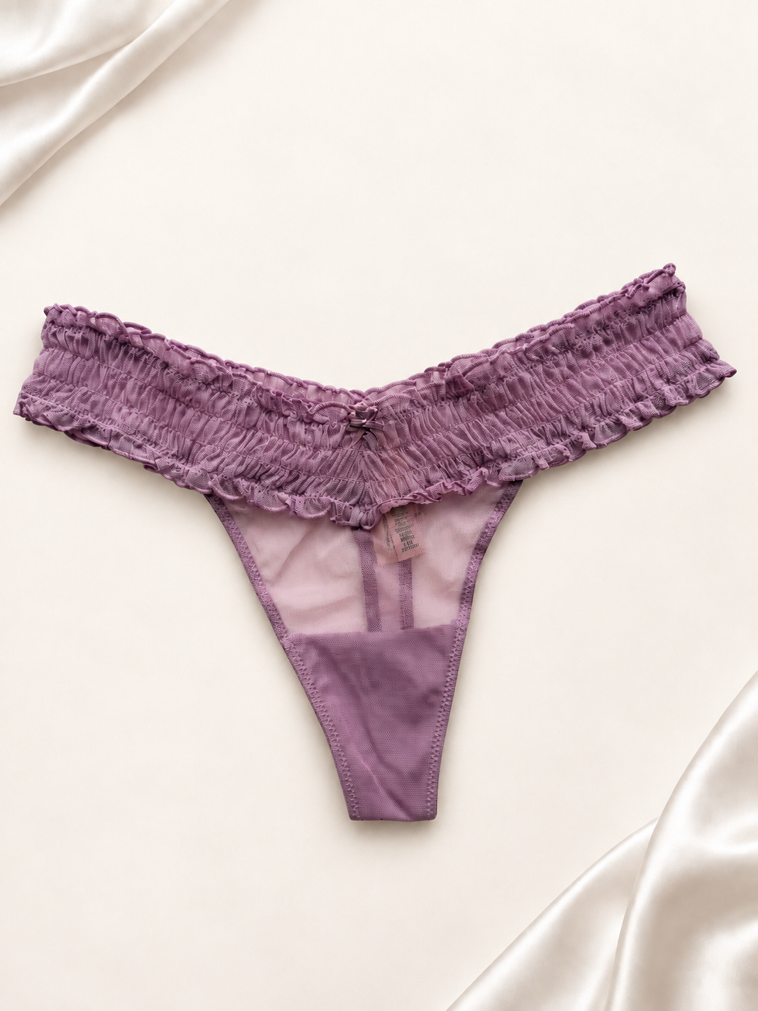Panti V'S de Encaje Violeta con Volados, vista frontal sobre fondo marfil
