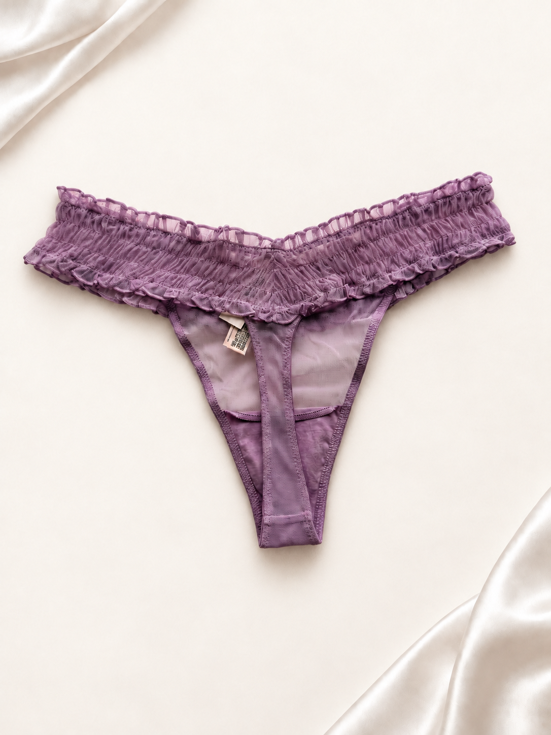 Panti V'S de Encaje Violeta con Volados, vista dorsal sobre fondo marfil