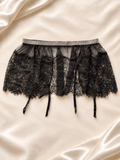 Pollera negra de encaje con cintura brillante y portaligas, vista frontal