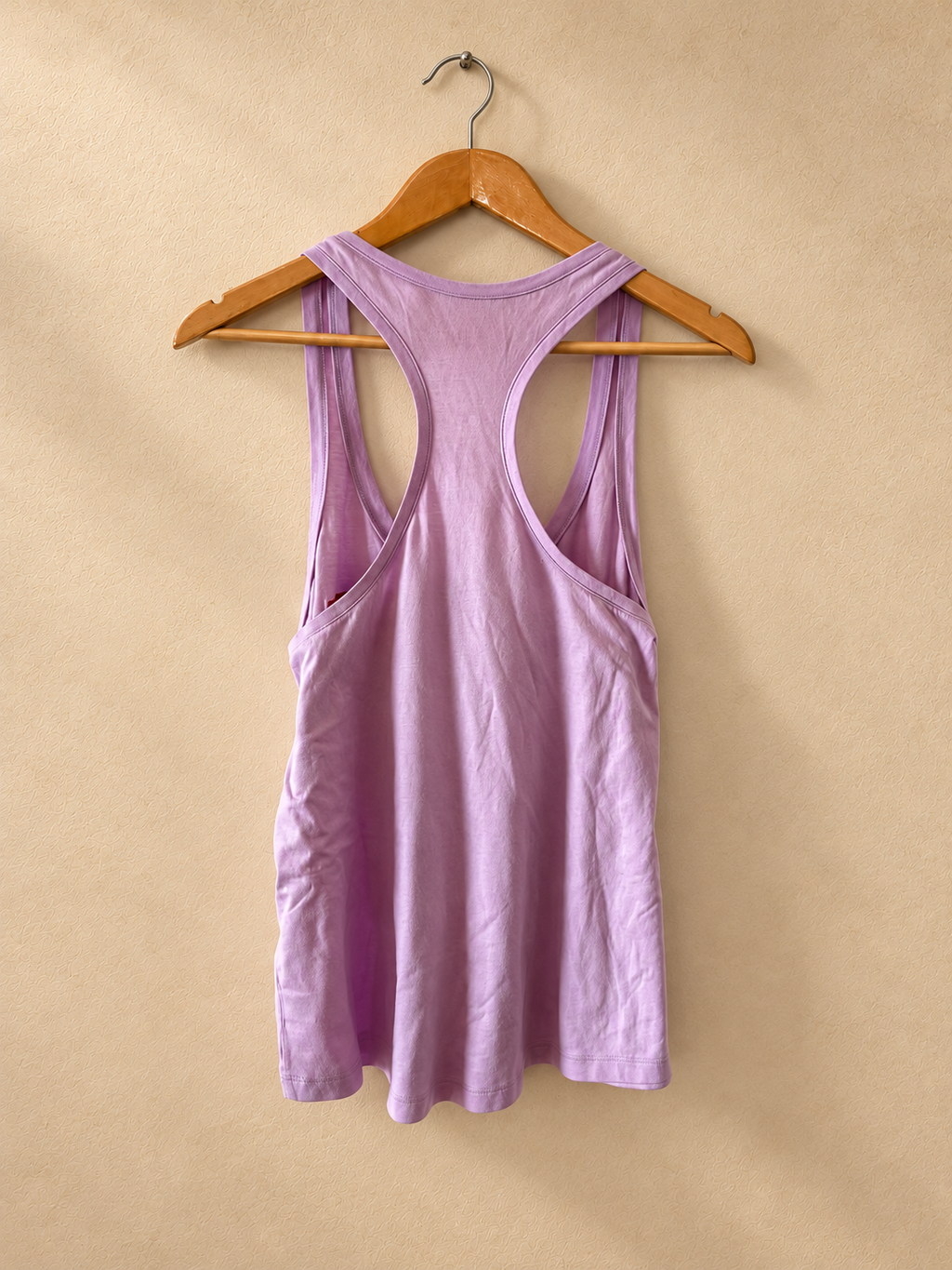 Dorso de Musculosa V'S PINK Lila con Corazón y Espalda Nadadora sobre fondo piedra cálida