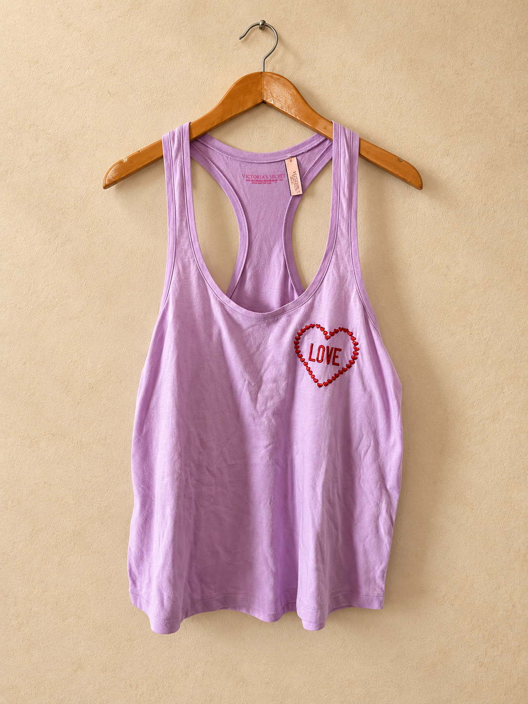 Frente de Musculosa V'S PINK Lila con Corazón y Espalda Nadadora sobre fondo piedra cálida