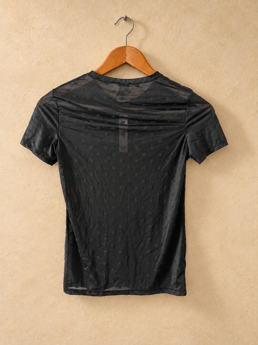 Dorso de Remera PINK Negra con Flores Tonales sobre fondo piedra cálida