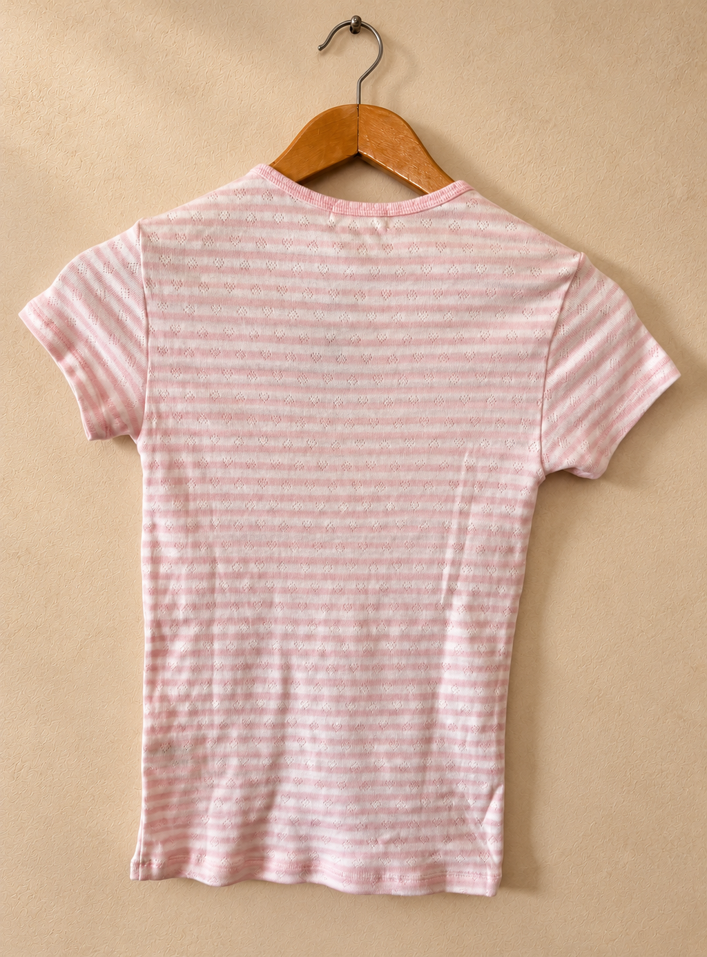 Dorso de Remera PINK Rosa y Blanca a Rayas con Microcorazones sobre fondo piedra cálida