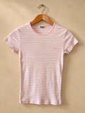 Frente de Remera PINK Rosa y Blanca a Rayas con Microcorazones sobre fondo piedra cálida