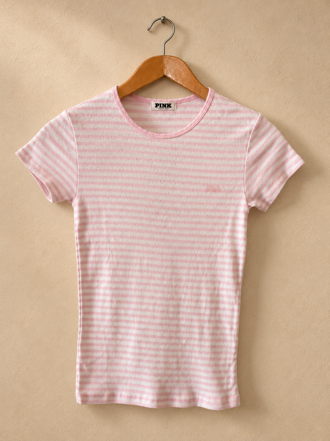 Frente de Remera PINK Rosa y Blanca a Rayas con Microcorazones sobre fondo piedra cálida