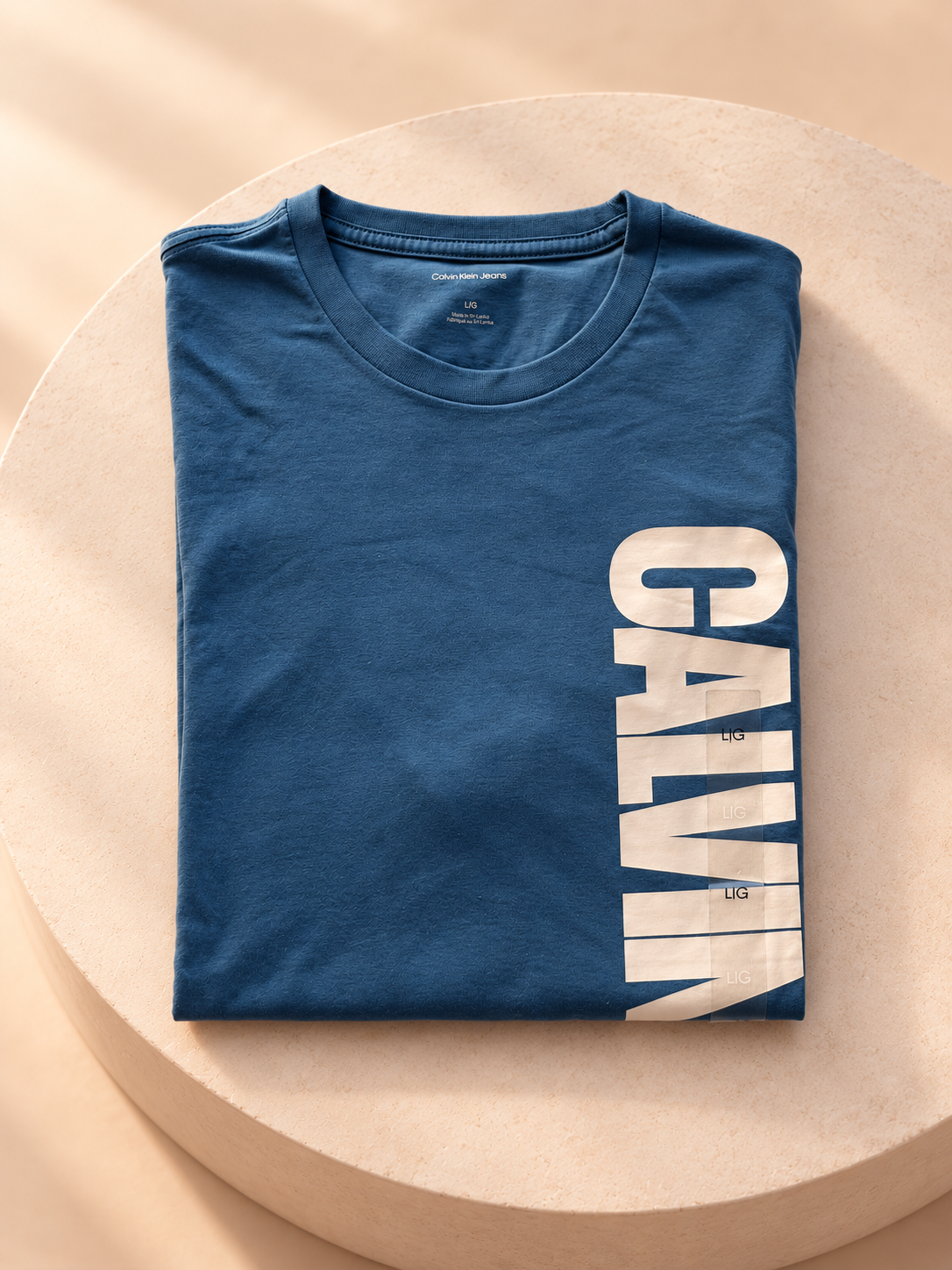 Remera Calvin Klein azul con logo vertical, vista plegada