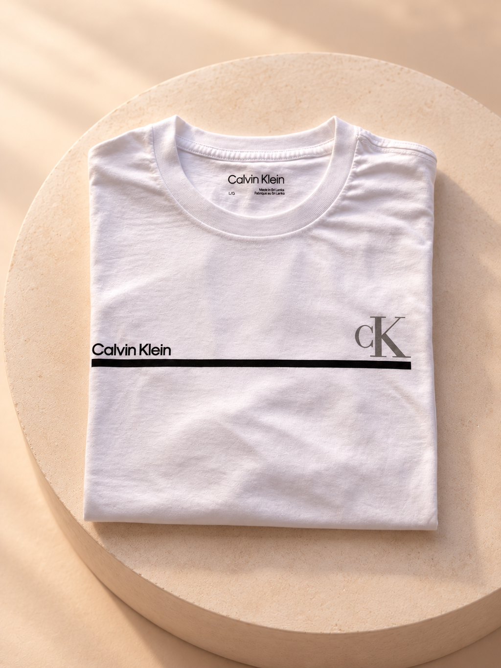 Remera Calvin Klein blanca con línea y logo CK, vista plegada