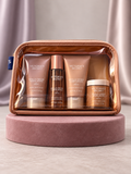 Set V'S Vanilla Orchid Sandalwood en neceser transparente, vista frontal sobre base rosa con cortinas malva