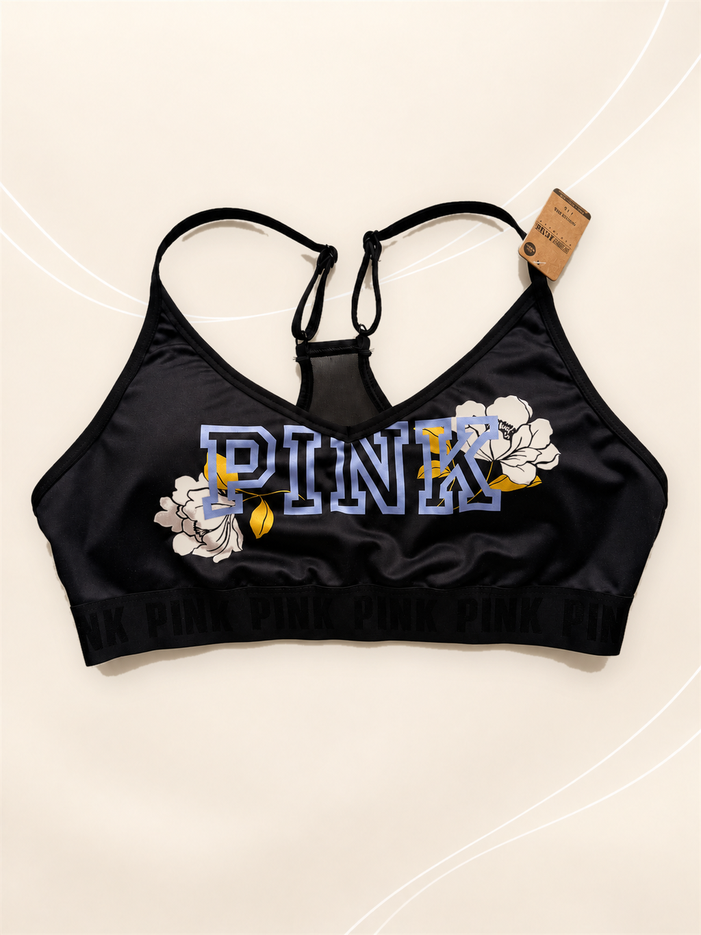 Corpiño Deportivo V'S Negro con Estampado Floral, vista frontal sobre fondo crema de líneas suaves