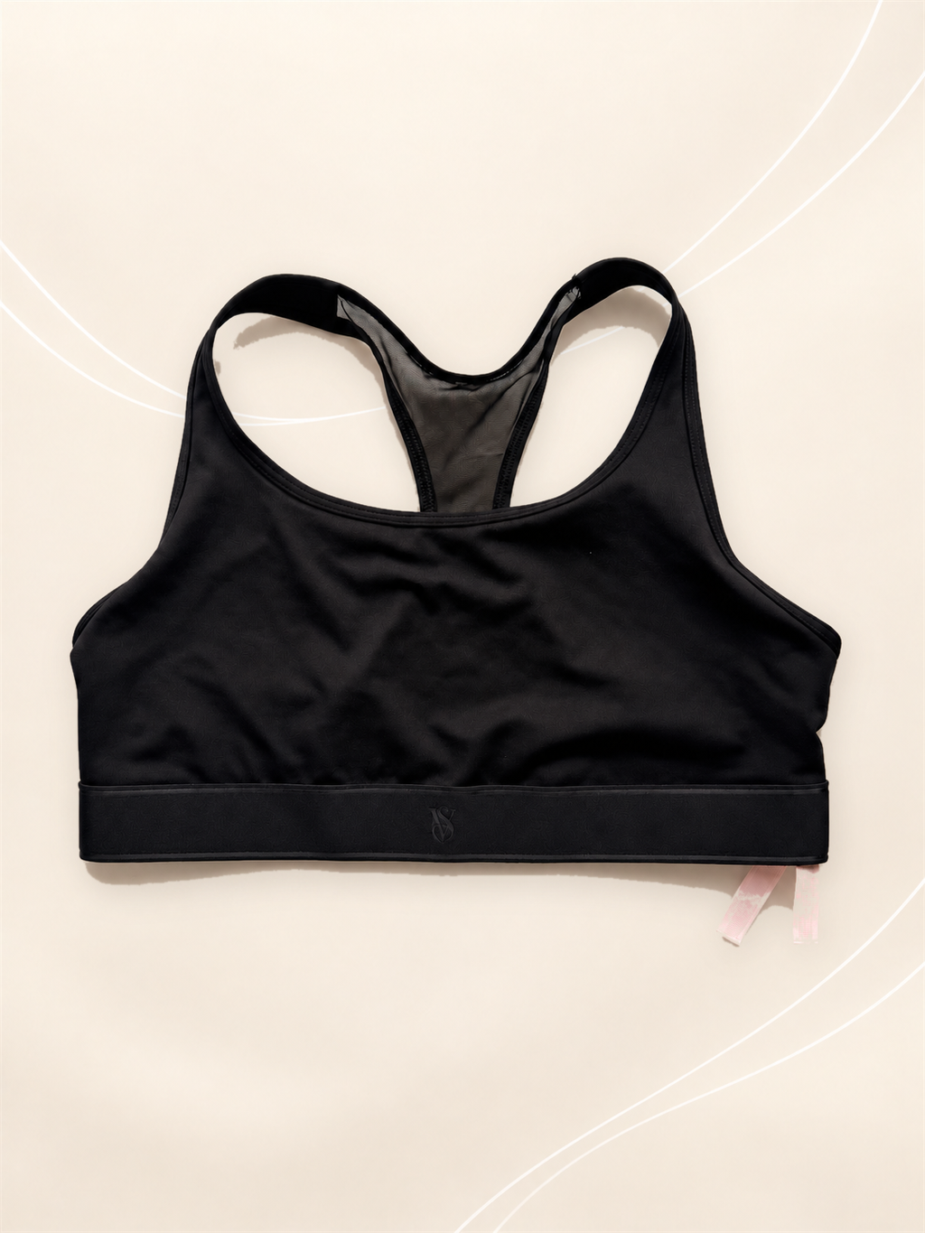 Corpiño Deportivo V'S Negro Racerback, vista frontal sobre fondo crema de líneas suaves