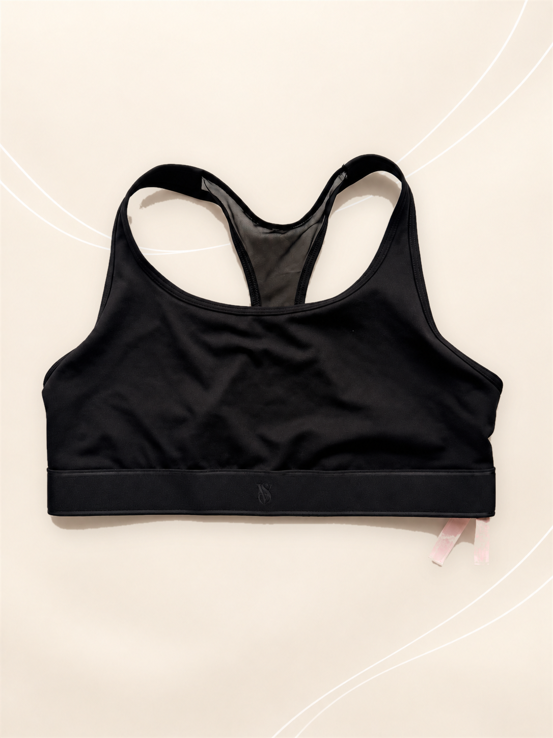 Corpiño Deportivo V'S Negro Racerback, vista frontal sobre fondo crema de líneas suaves